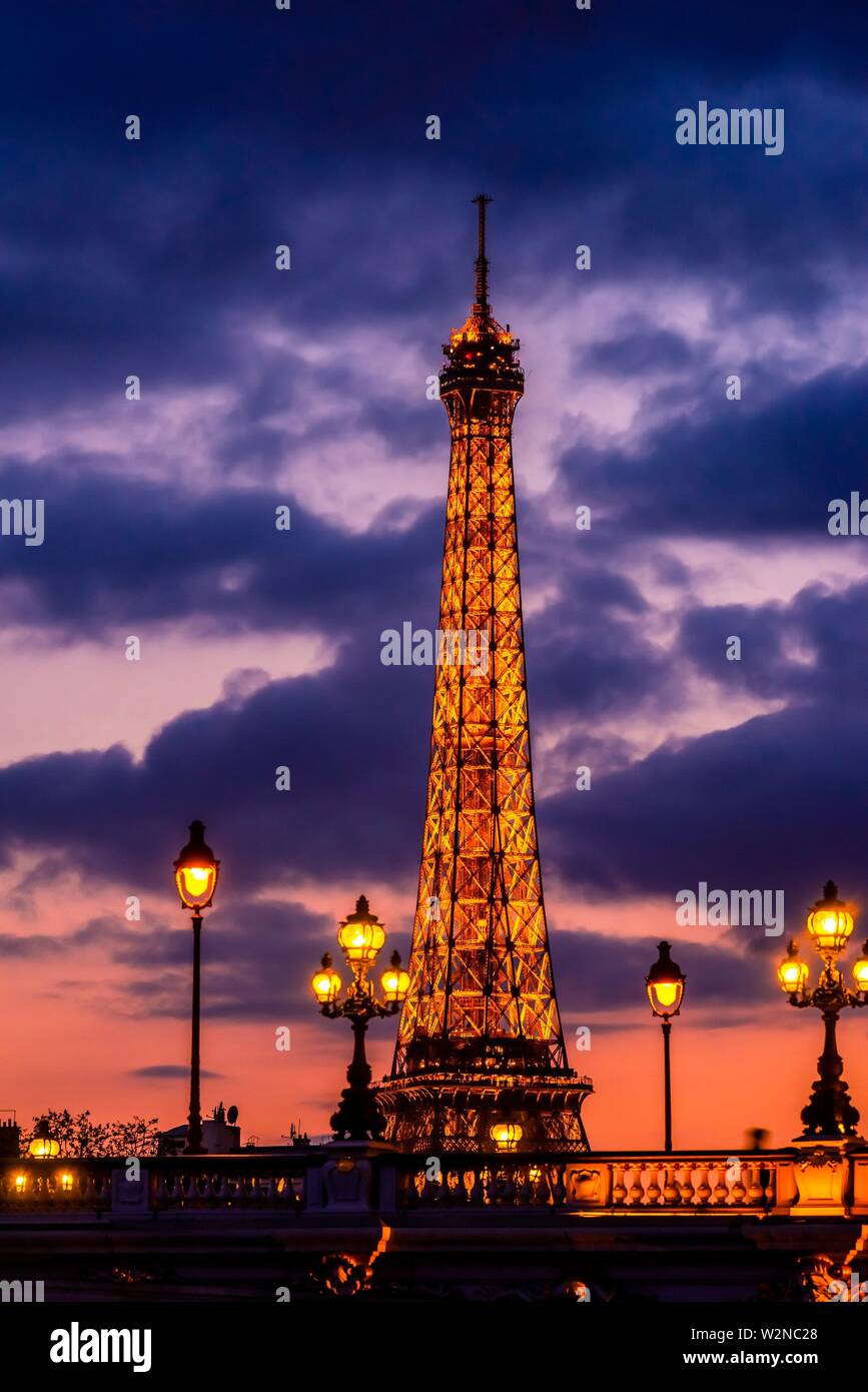 Illuminata di art nouveau lampade dell'ornato Pont Alexandre III (ponte) con la Torre Eiffel sullo sfondo, Parigi, Francia. Foto Stock