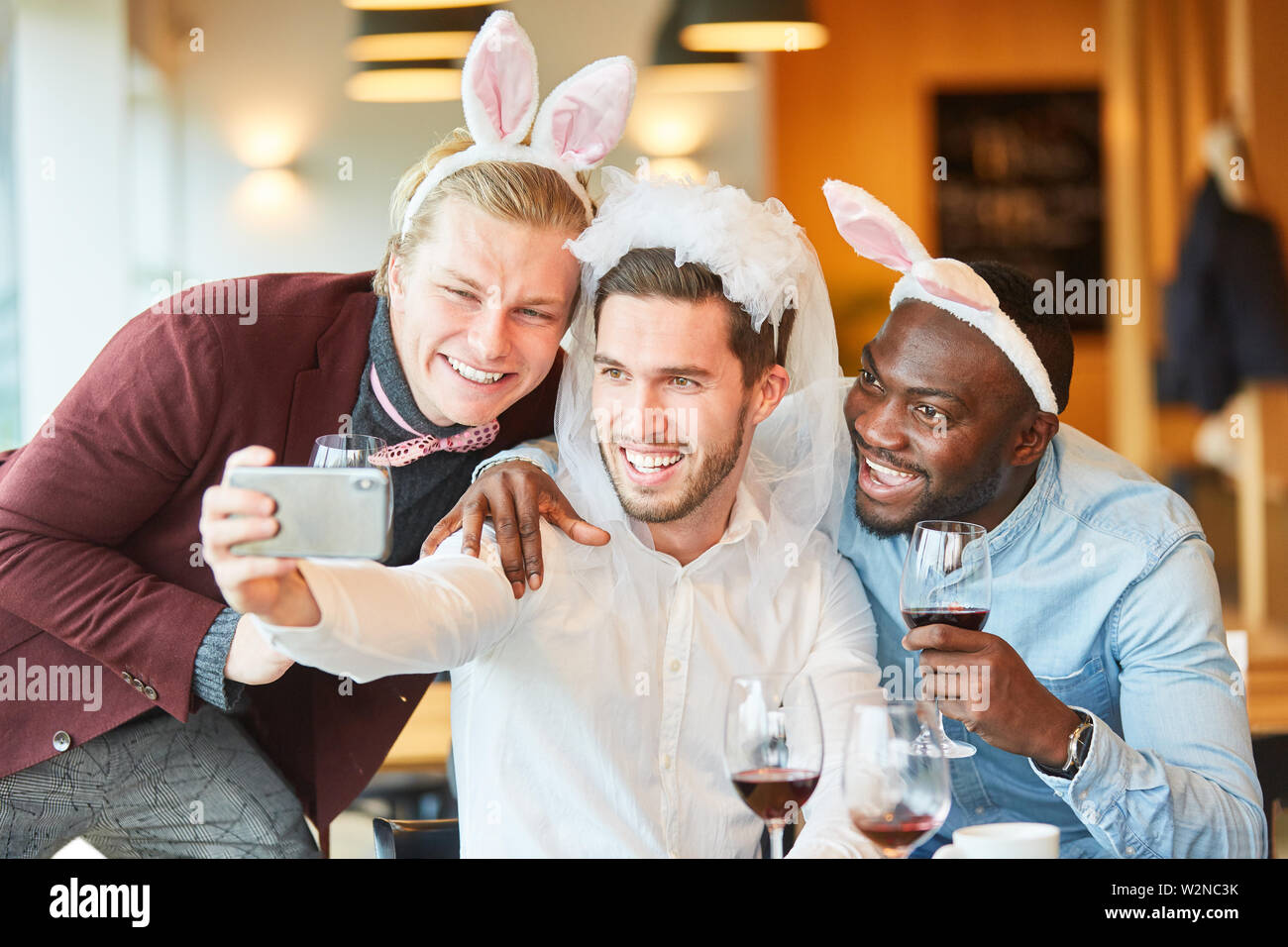 Amici a livello di bachelor party in divertente travestimento prendere un selfie Foto Stock