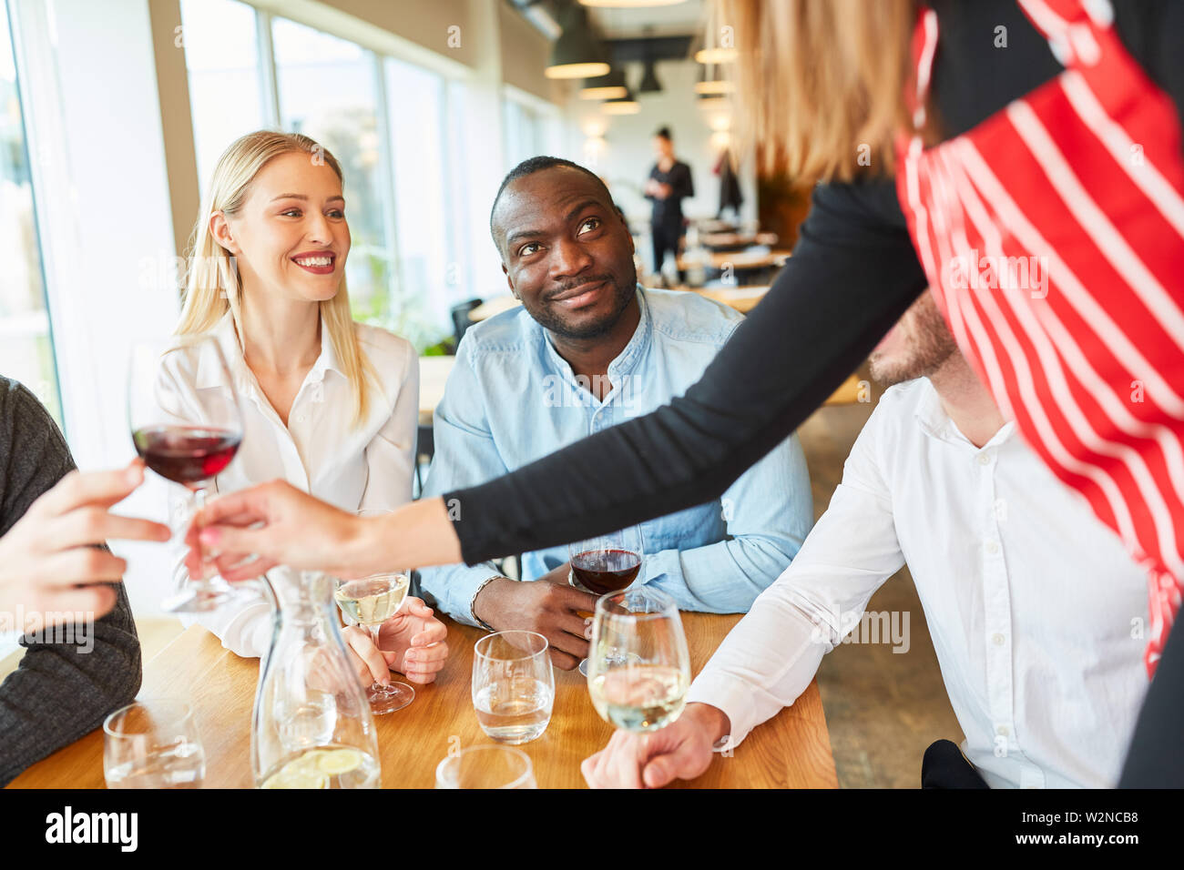 Il personale di servizio come un aiuto temporaneo servito giovane e amici nel ristorante o nel bistrot Foto Stock