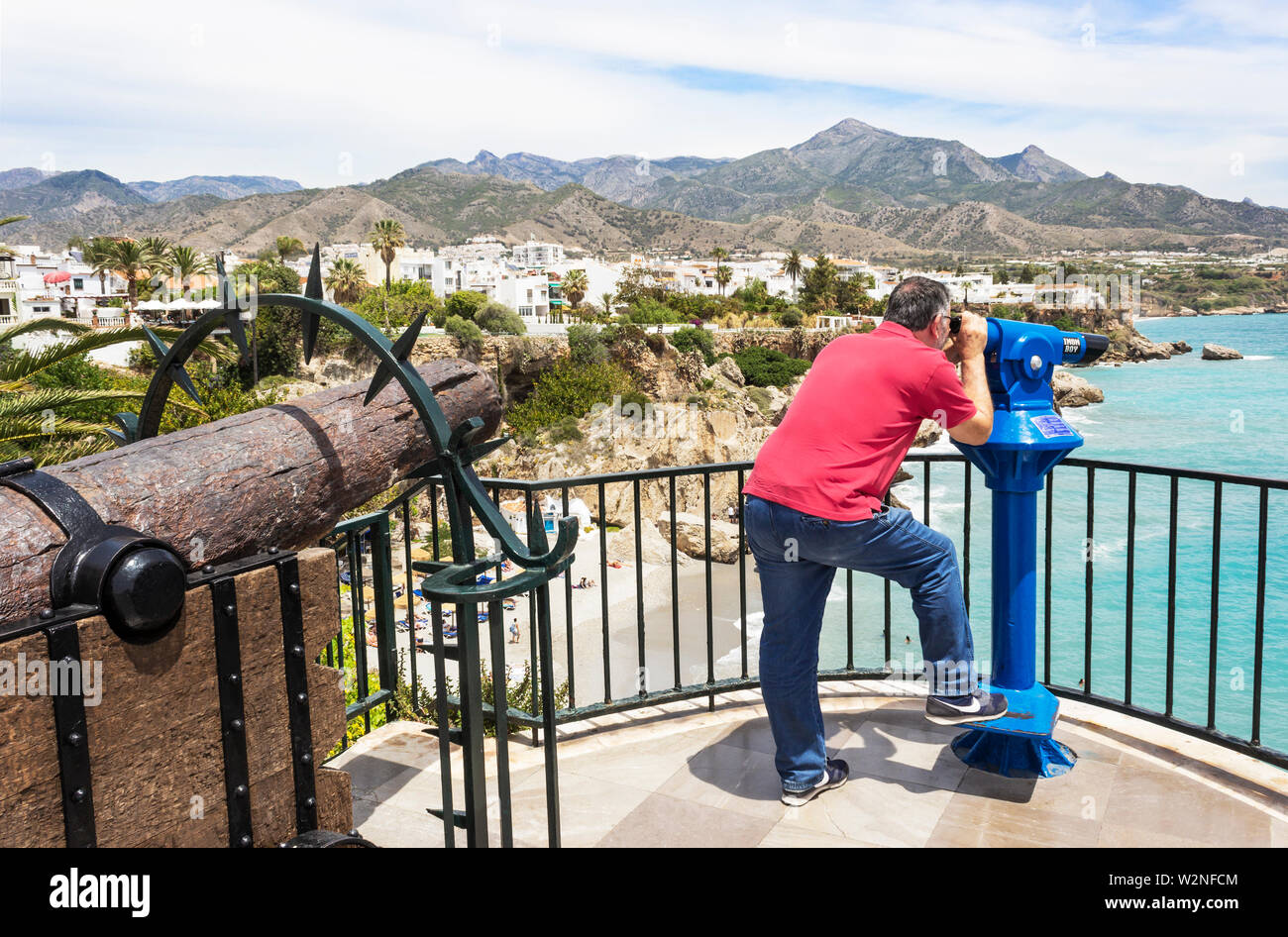 Nerja, Malaga, Costa del Sol, Andalusia, Spagna. Uomo che guarda la vista attraverso un telescopio. Foto Stock