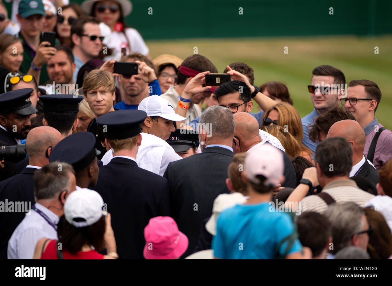 Rafael Nadal fa il suo modo attraverso la folla di spettatori dopo una sessione di prove libere il giorno nove dei campionati di Wimbledon al All England Lawn Tennis e Croquet Club, Wimbledon. Foto Stock