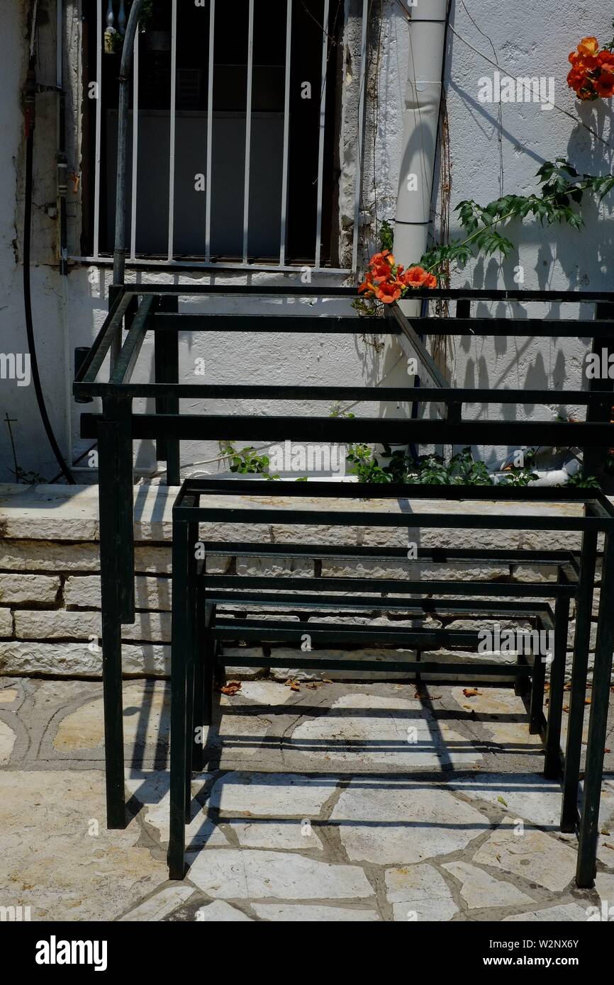 Corfù quadro di metallo in un cortile della chiesa a Kassiopi.sicuri di utilizzare impilati vicino a una finestra sbarrata Foto Stock