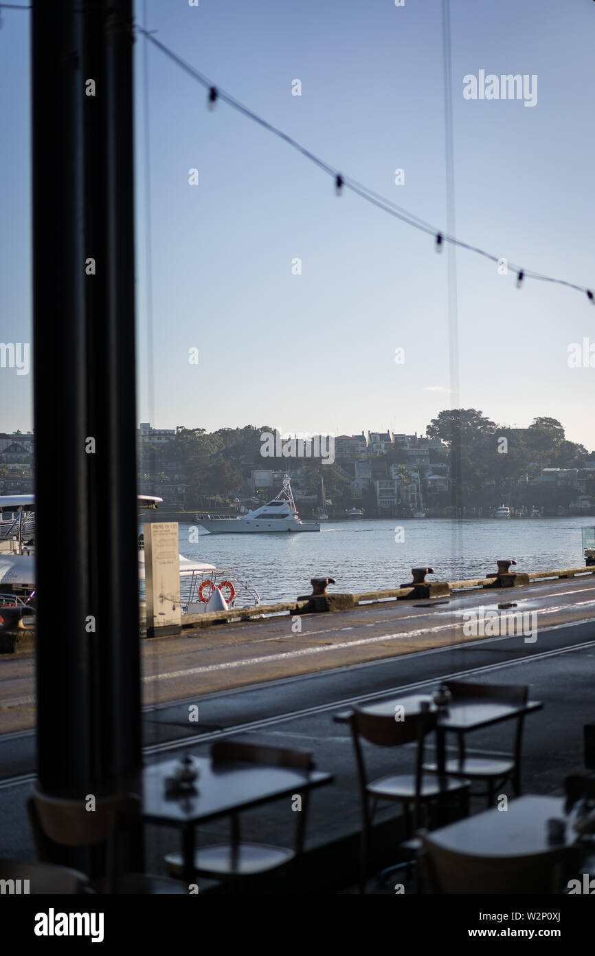Guardando a una barca in acqua da un cafe su Jones Bay Wharf al mattino. Sydney NSW. Giugno 2019 Foto Stock