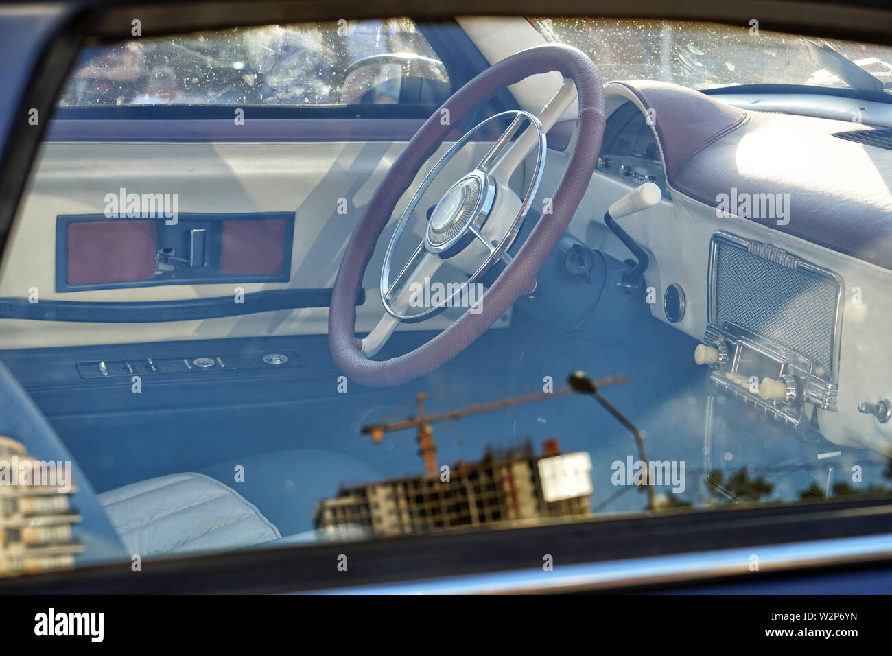 L'interno di un automobile retrò è un vista laterale, interni in pelle e il vecchio volante, un classico cruscotto. Foto Stock