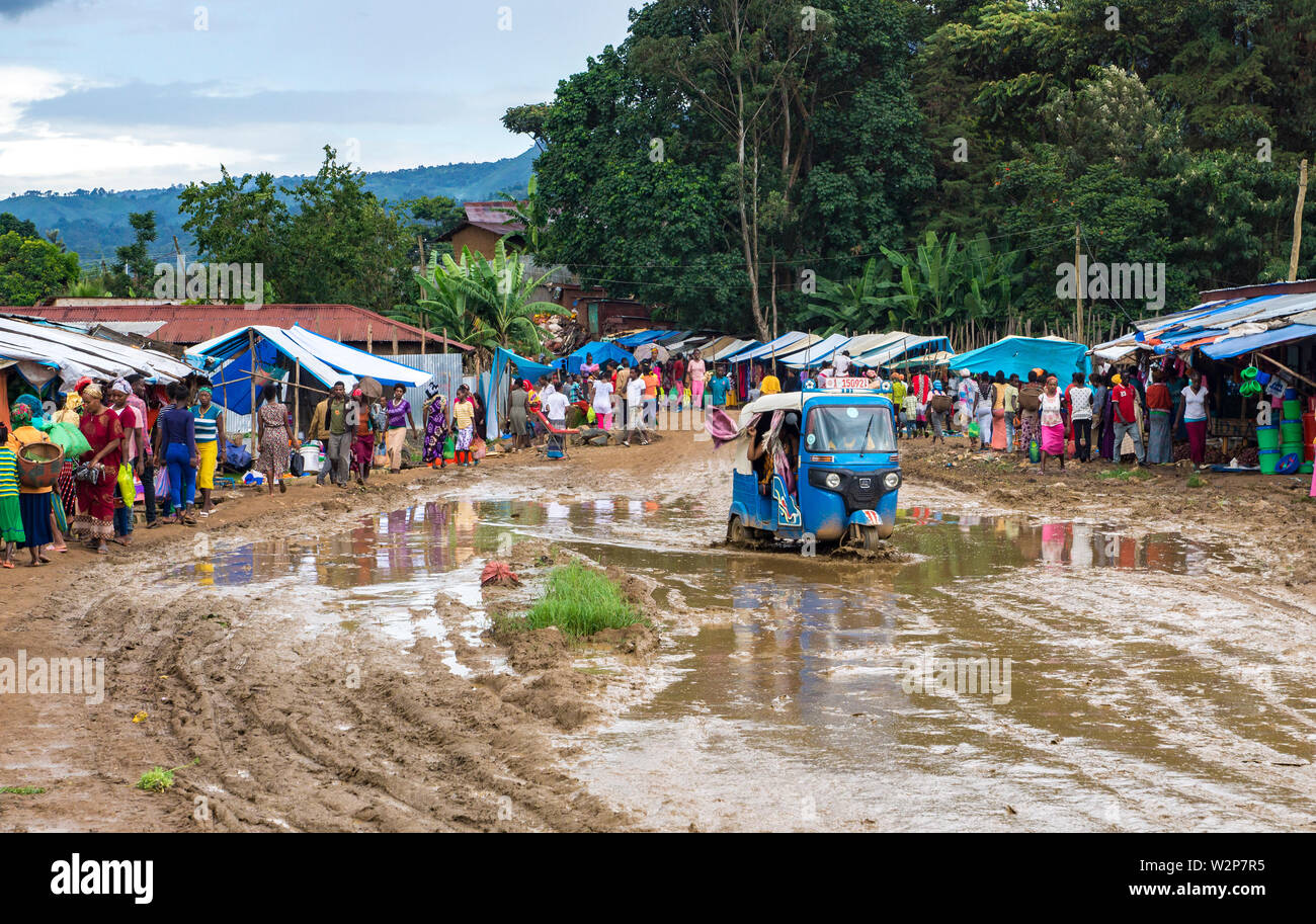 Un Tuk Tuk guidando attraverso il fango Mizan Teferi street, Etiopia Foto Stock