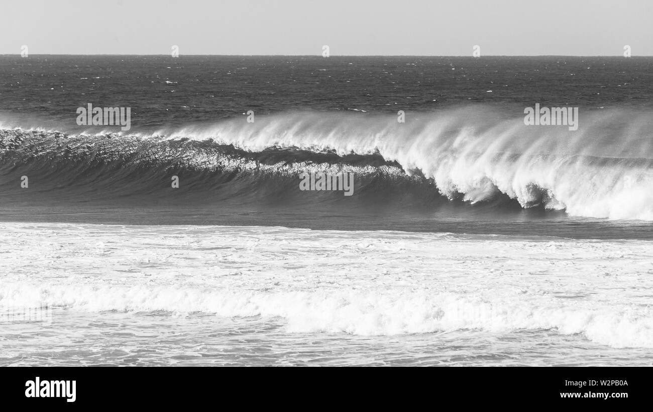 Oceano onda affacciato sul blocco con il vento in spray vintage foto in bianco e nero. Foto Stock