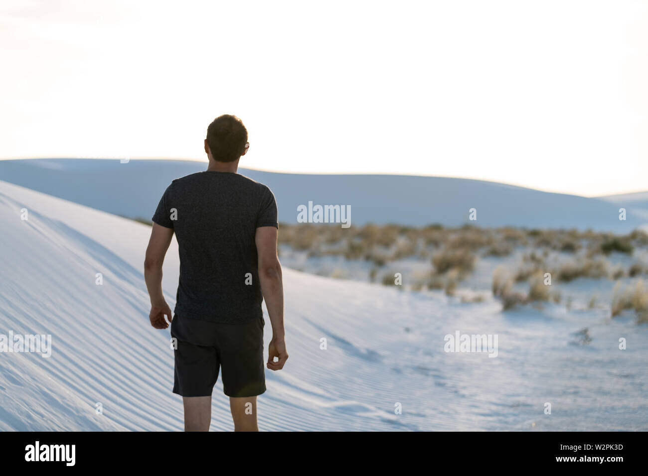 L'uomo torna a camminare sulla sabbia in sabbie bianche dune monumento nazionale nel Nuovo Messico guardando il tramonto Foto Stock