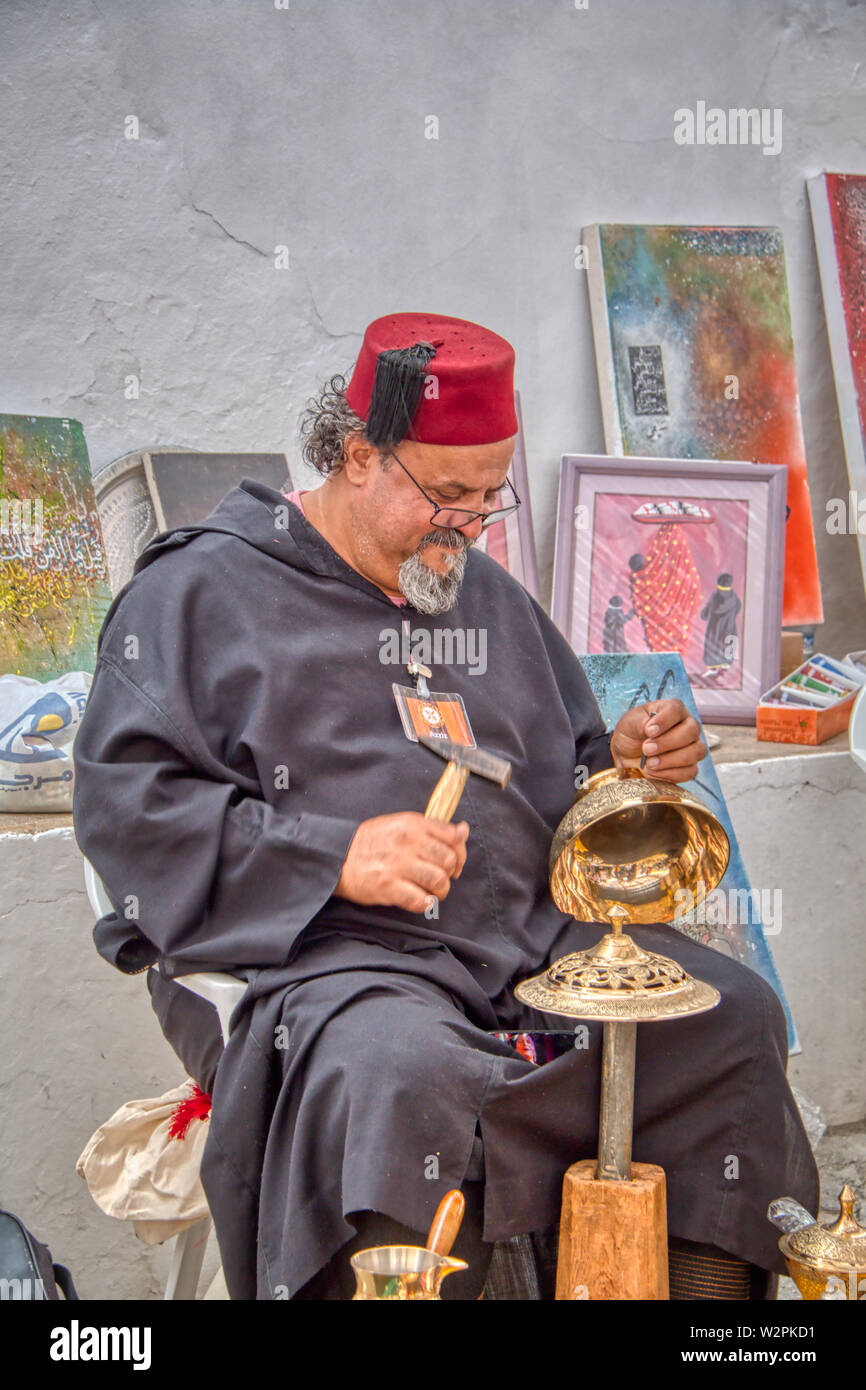 Mertola, Portogallo - 18 Maggio 2019: marocchina artigiano carving bellissimi oggetti metallici nelle strade di Mertola, dove la festa islamica è tenuto alla vigilia Foto Stock