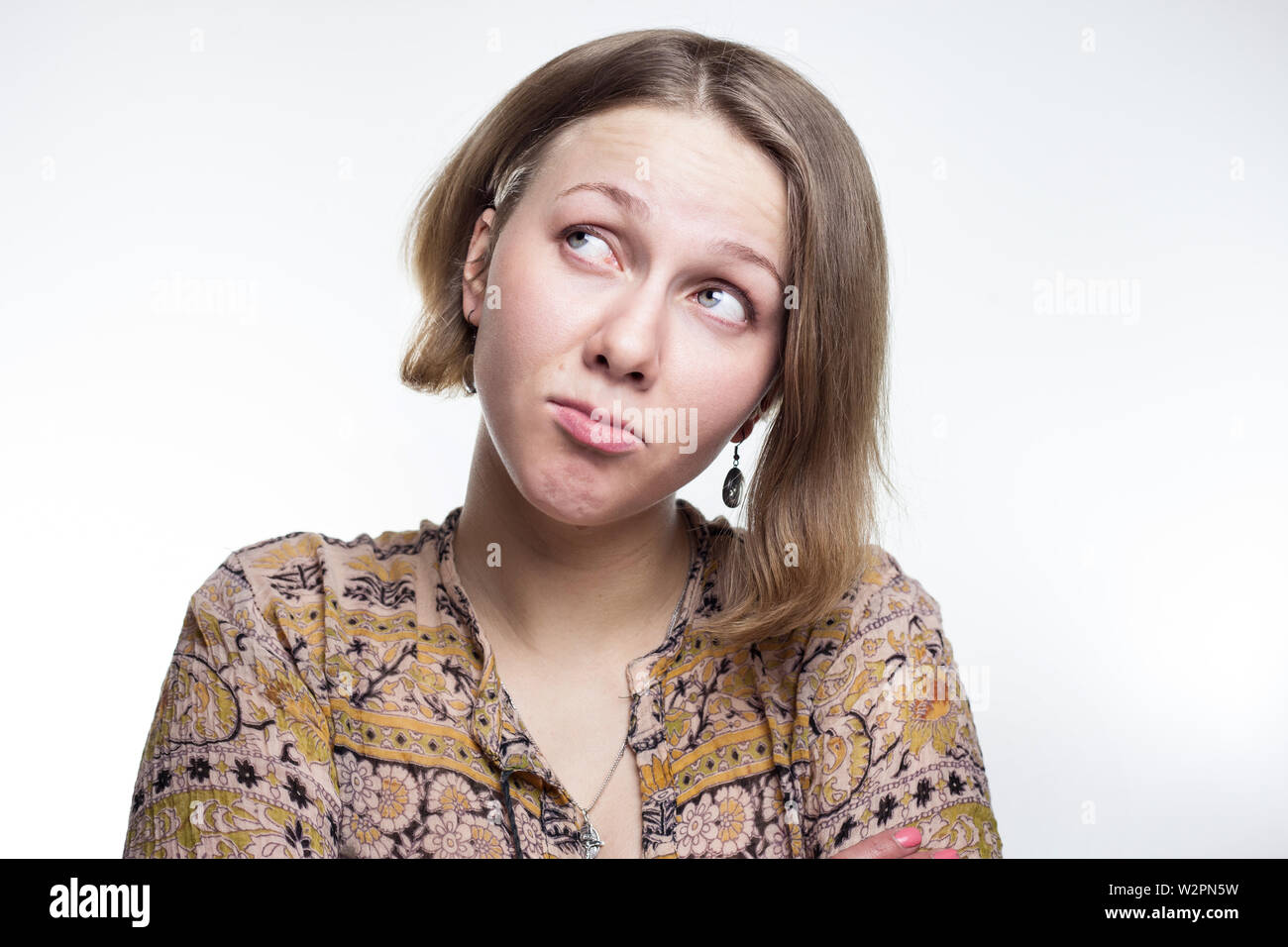 Una foto ritratto di un flirtatious, civettuolo ragazza giovane con metà capelli biondi. Busbana francese e guardando coquettishly, flirty su grigio di sfondo per studio. offeso donna. capriccioso, broncio, tengono il broncio adolescente Foto Stock