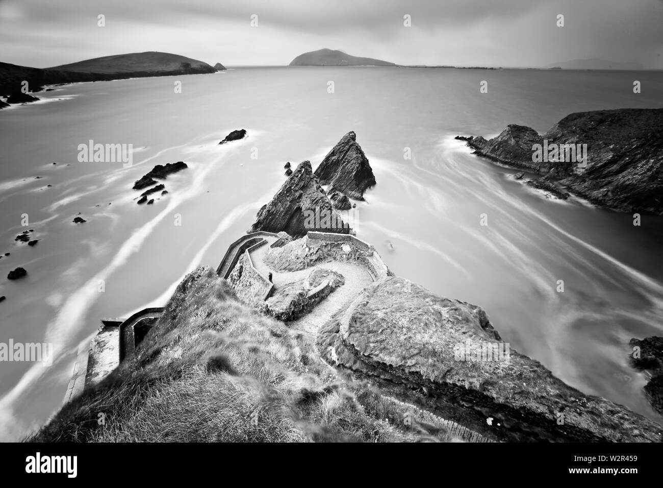 Dunquin Harbour, co. Kerry / Irlanda : Rocky strada costiera occidentale che conduce a Dunquin Harbour con la Grande Isola di Blasket visibile nella lontano dis Foto Stock