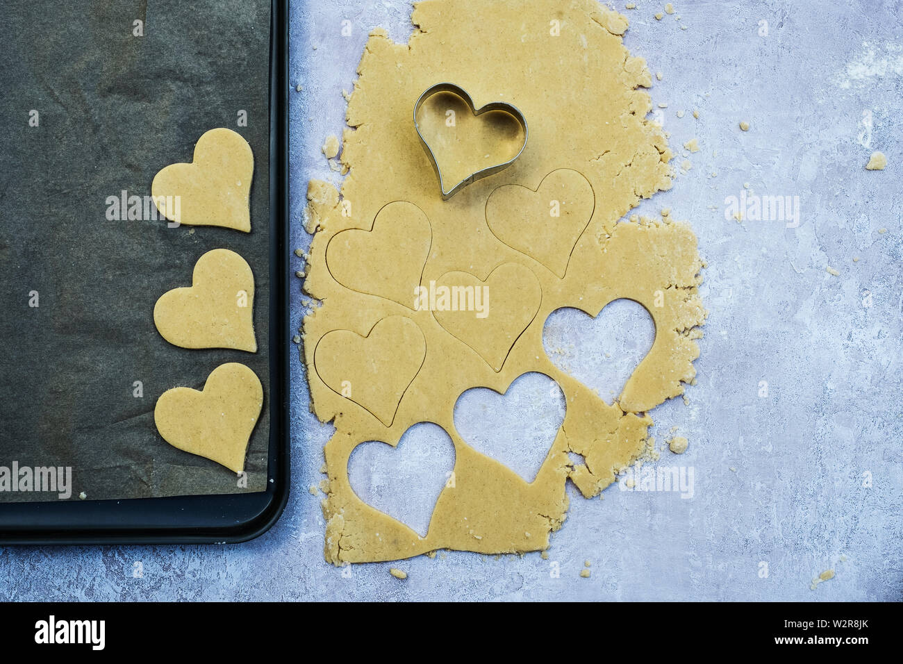 Angolo alto close up a forma di cuore i cookie tagliato fuori della pasta biscotto. Foto Stock