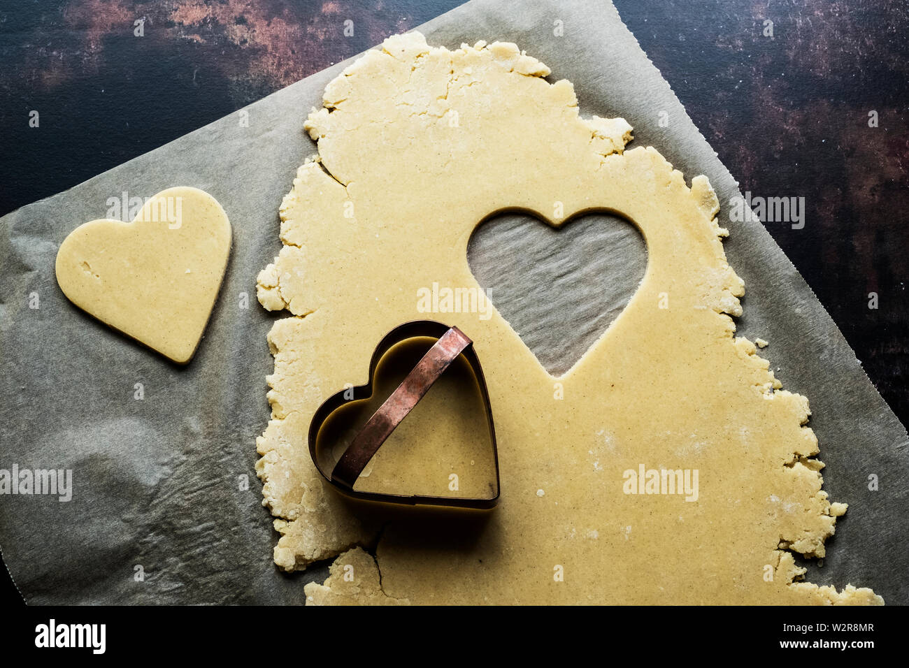 Angolo alto close up a forma di cuore i cookie tagliato fuori della pasta biscotto. Foto Stock