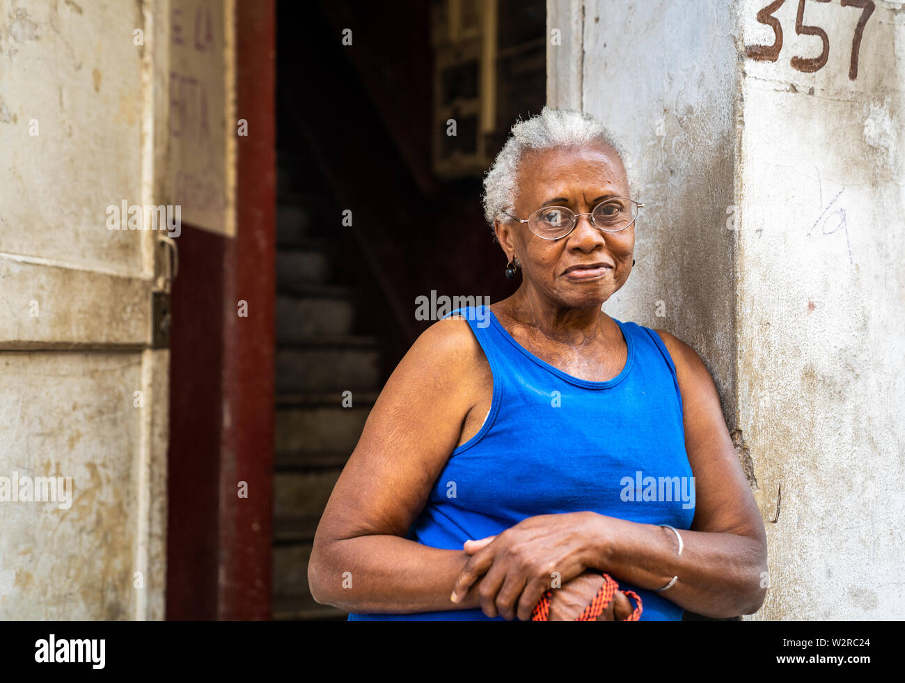 Vecchia Havana, Cuba - Gennaio 2, 2019: un senior Afro-cubano sta femmina al di fuori del suo appartamento casa nella Vecchia Havana, Cuba. Foto Stock