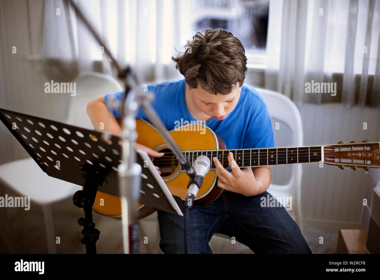 Il ragazzo si siede a suonare la chitarra. Foto Stock