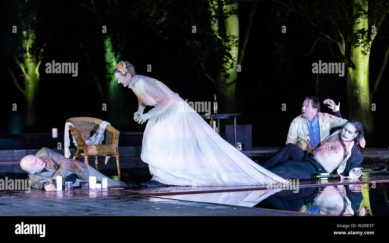 A Mülheim an der Ruhr, Germania. Il 4 luglio 2019. L-R: Klaus Herzog, Simone Thoma, Albert Bork, Fabio Menéndez. Theater an der Ruhr performes durante la Weiße Nächte stagione in Raffelbergpark Eugene O'Neill giocare 'Eines langen Tages Reise in Die Nacht' (lunga giornata di viaggio nella notte) diretto da Roberto Ciulli. Con Simone Thoma (Mary Tyrone), Klaus Herzog (James Tyrone), Fabio Menéndez (James Tyrone Jr.) e Albert Bork (Edmund Tyrone). Il free open-air spettacoli si svolgono dal 4 al 7 luglio 2019. Foto Stock