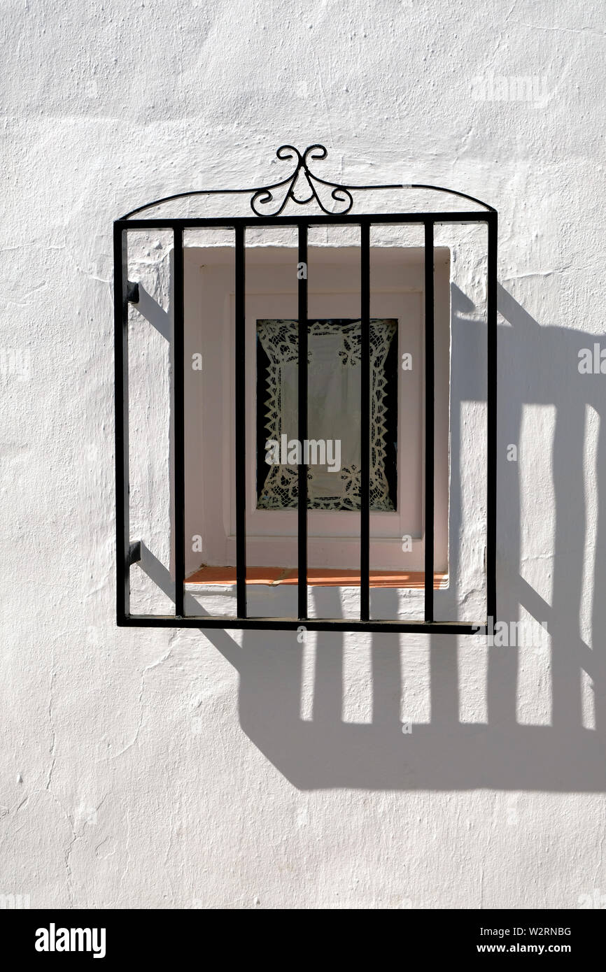 Casa decorativi con finestra in ferro battuto nel villaggio di montagna di Frigiliana, provincia di Malaga, in Spagna; la mattina presto su una soleggiata giornata estiva. Foto Stock