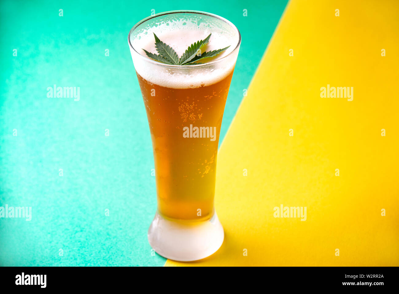 Dettaglio del vetro freddo di birra con cannabis leaf, marijuana bevanda infusa concept Foto Stock