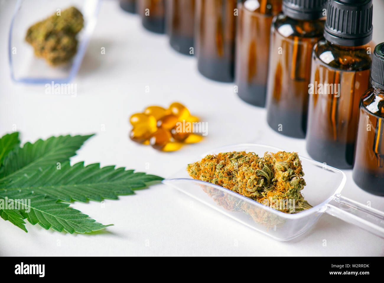 Un assortimento di prodotti a base di cannabis cannabis inclusa tintura o olio di CBD, essiccato nugs e capsule isolato su bianco, la marijuana medica nozione Foto Stock