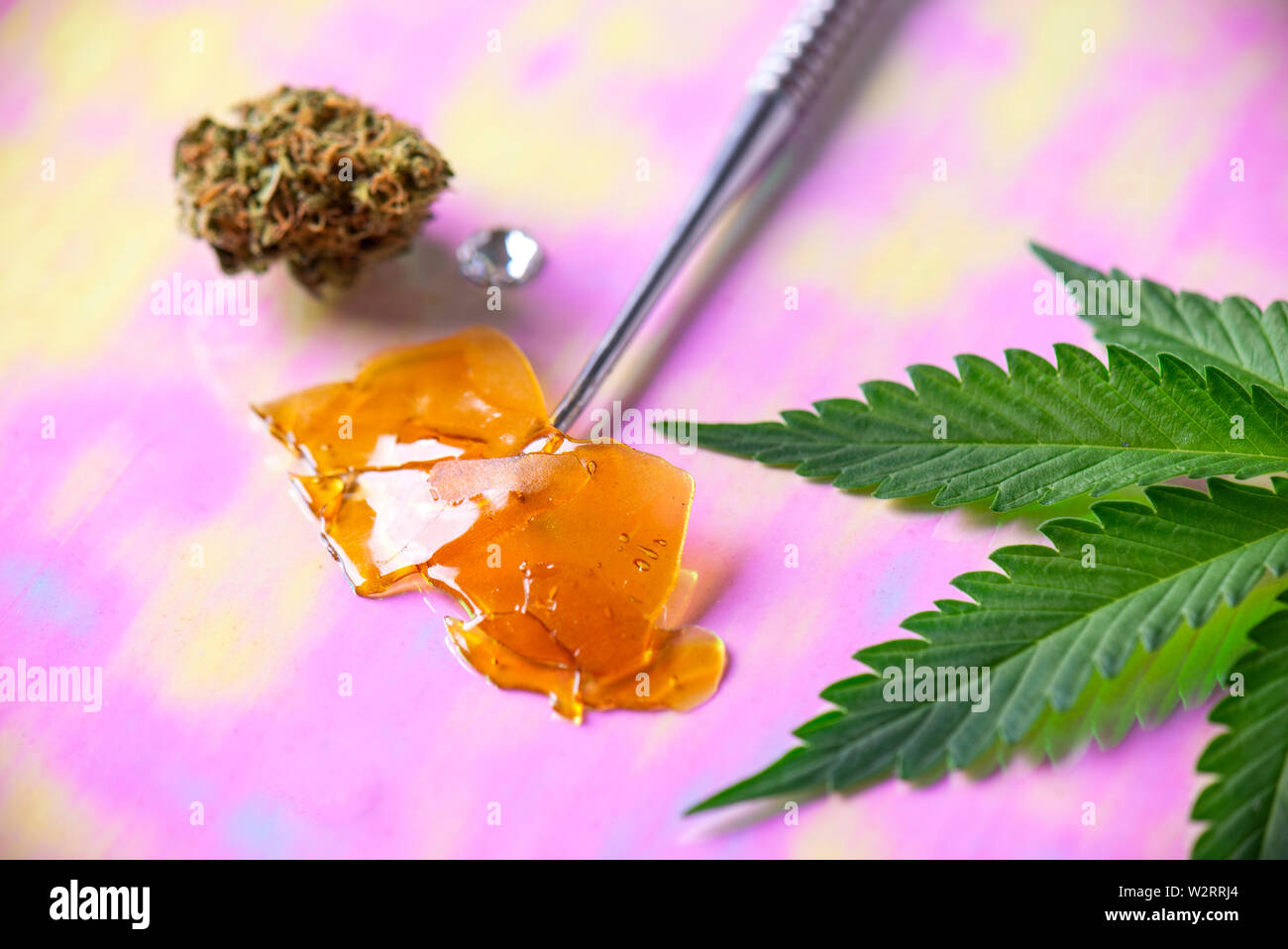 Macro dettaglio di strumento dab con concentrato di cannabis aka frantumare e foglia di marijuana, cannabis concetto di estrazione Foto Stock