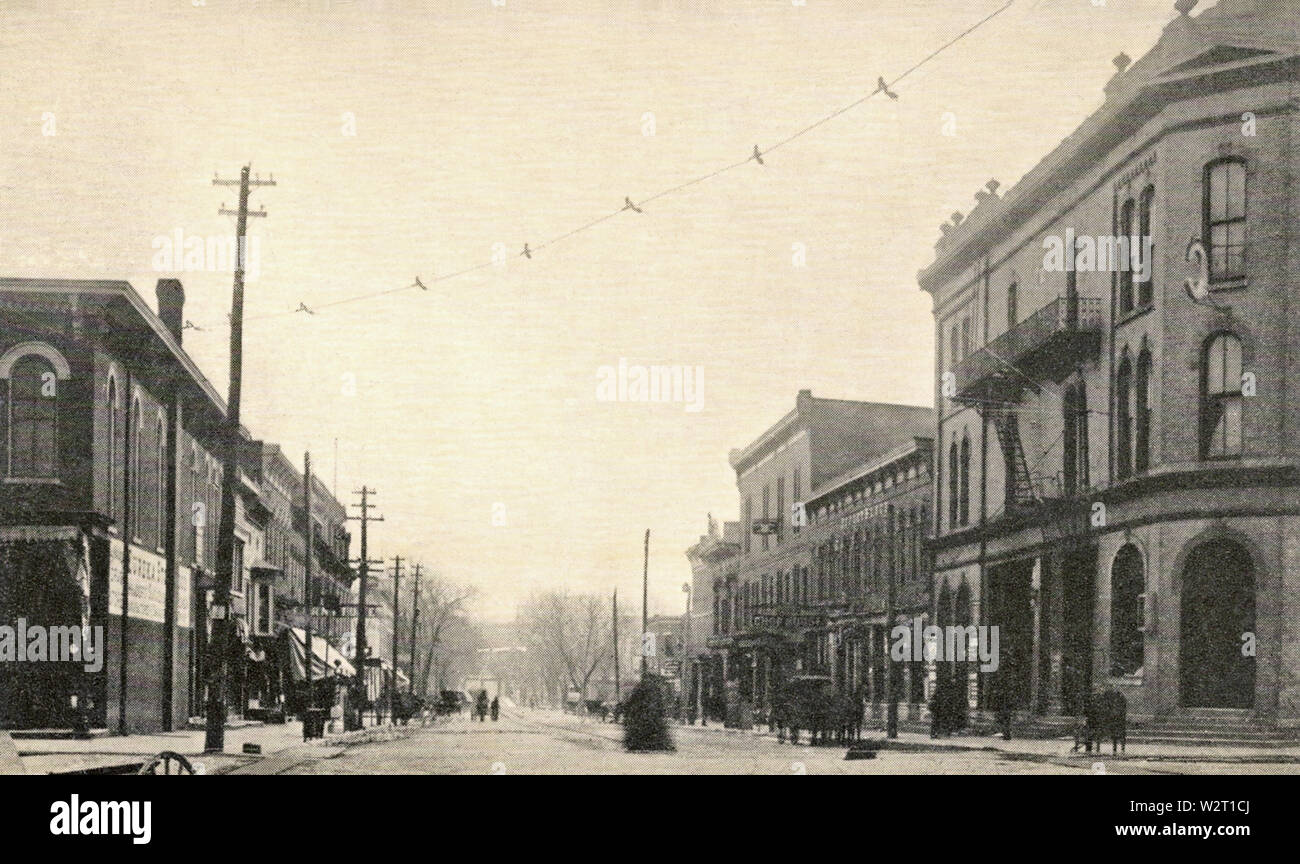 Coldren storica Opera House appare al bordo destro di questa immagine da circa 1910. La guarda ad est lungo College dalla sua intersezione con Clinton Street a Iowa City, Iowa. Il Coldren luogo era il principale predecessore a Englert Theatre come host di esibizioni dal vivo nello Iowa City dalla sua apertura durante 1872 fino alla sua scomparsa con apertura di Macbride Auditorium all'University of Iowa campus durante il 1908 e il Englert durante il 1912. La delicatamente ricurva linea attraverso il cielo è un overhead di filo elettrico che fornita alimentazione al carrello vetture della ferrovia CRandIC il servizio interurbano Foto Stock