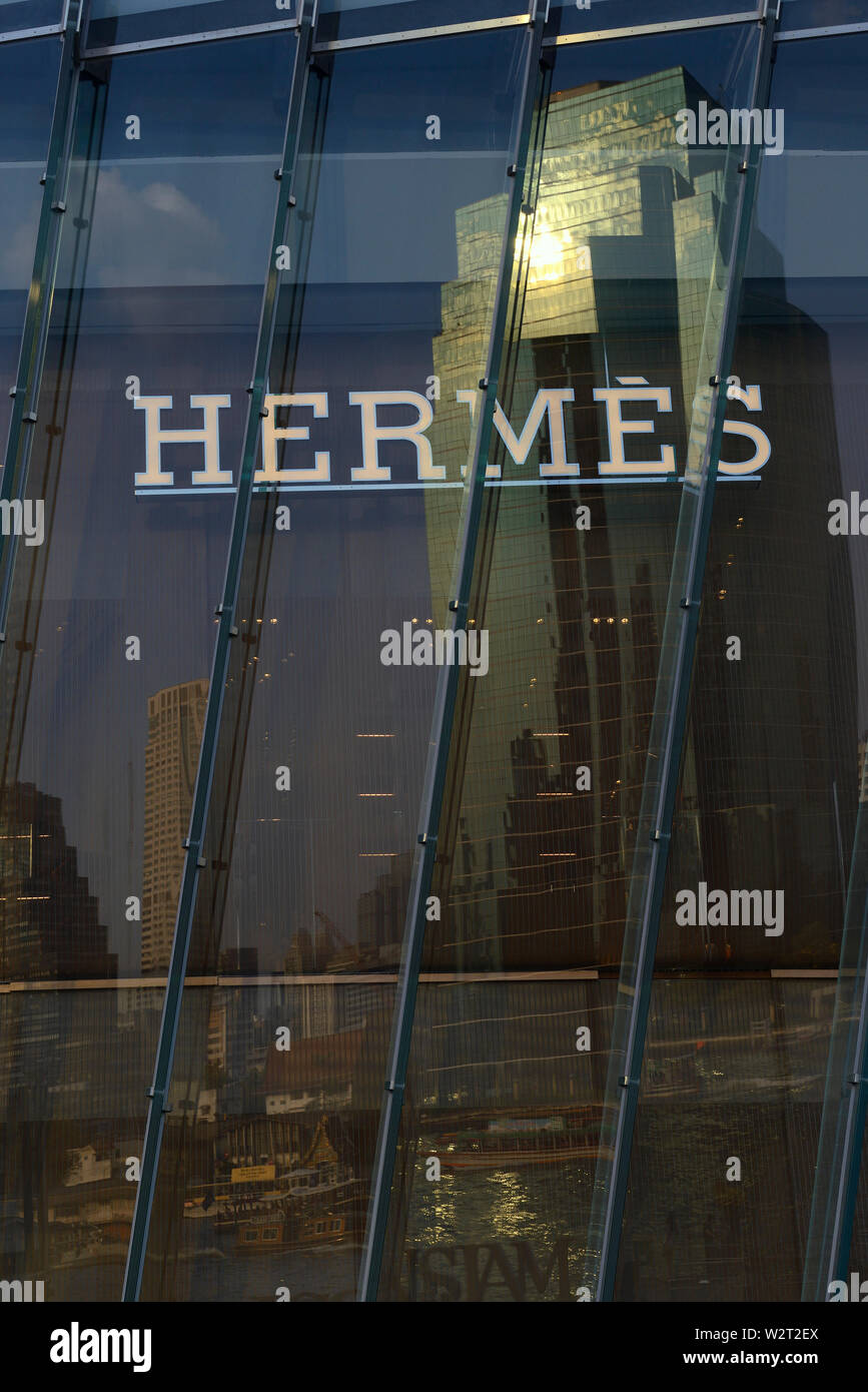 Bangkok, Tailandia - 20 gennaio 2019: finestra di iconsiam shopping mall con logo hermes riflettendo le opposte sponde del Mae Nam Chao Phraya Foto Stock
