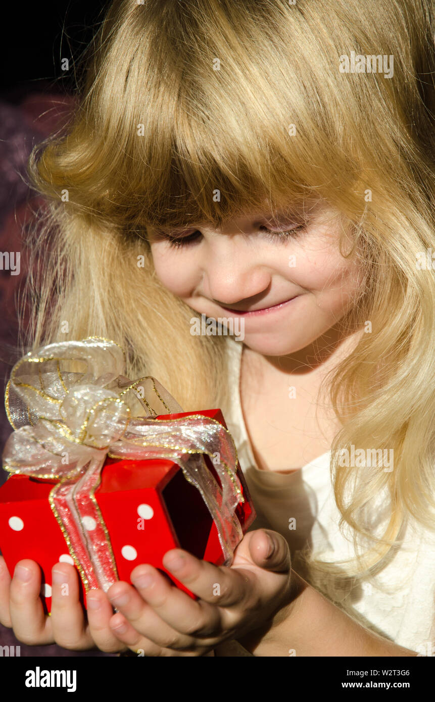 Bella ragazza bionda con regalo rossa in mani Foto Stock