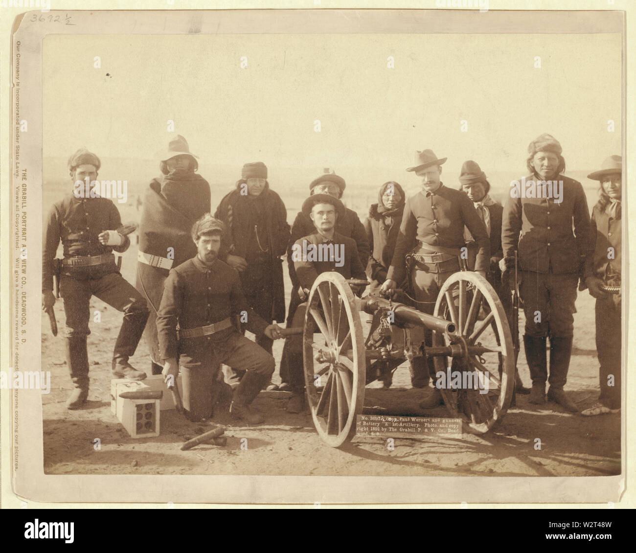 Copr. Paolo Wernert cioè Weinert e artiglieri della batteria e 1 Artiglieria / foto. e copyright 1891 dall'Grabill P. & V., Deadwood, S.D.; sette Lakota scout e quattro uniformata Euro-Americans poste dietro un pezzo di artiglieria o Hotchkiss pistola, probabilmente in Pine Ridge Reservation vicino a Wounded Knee, South Dakota. Foto Stock
