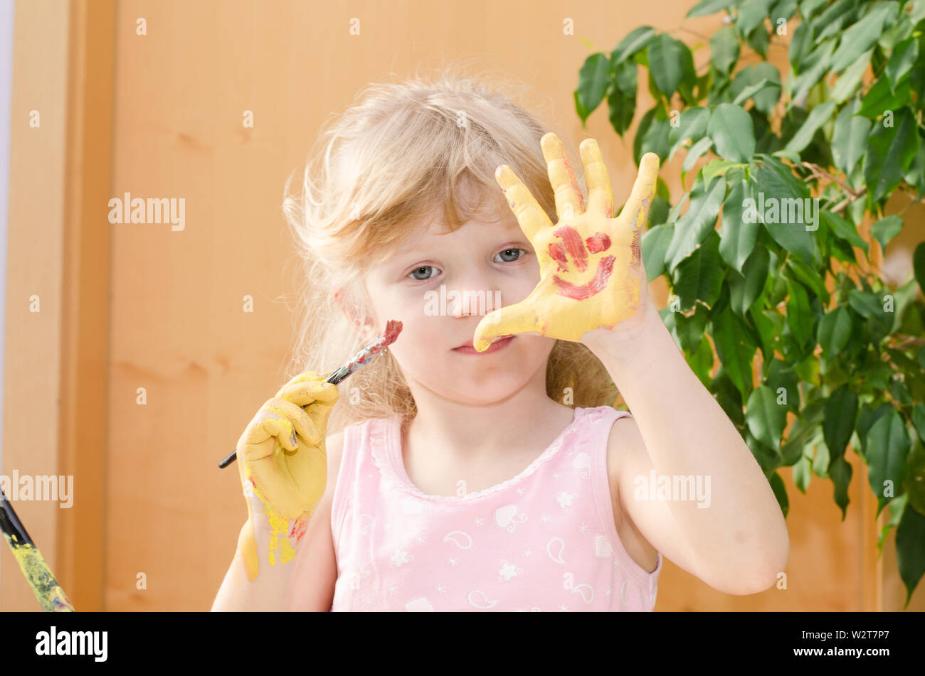 Ragazza bionda con verniciato giallo le mani Foto Stock