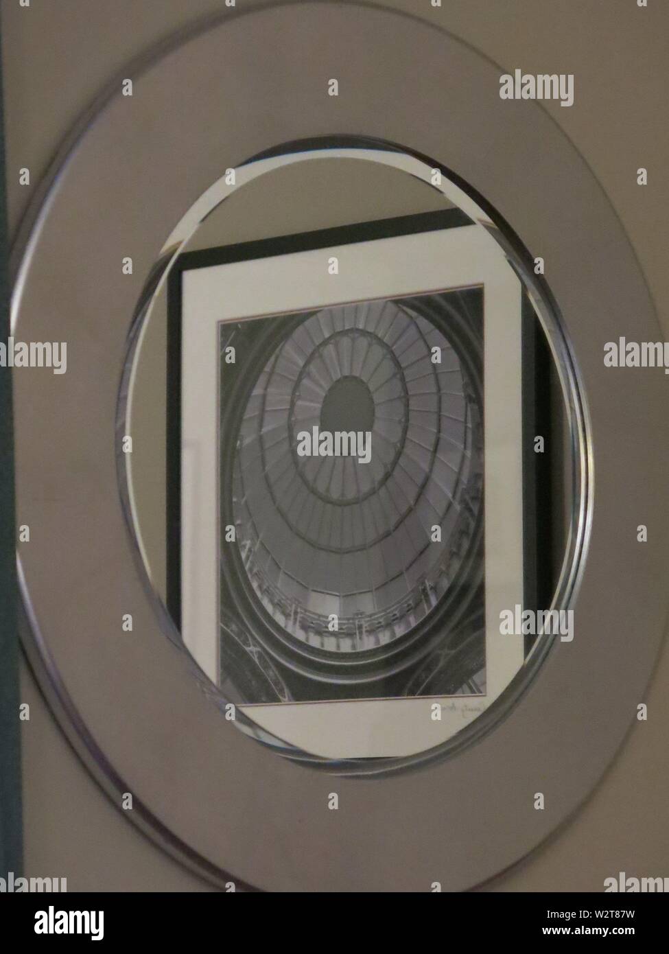 Un immagine astratta di cerchi entro le piazze entro un specchio circolare, in monotones di nero, bianco e grigio e argento. Foto Stock