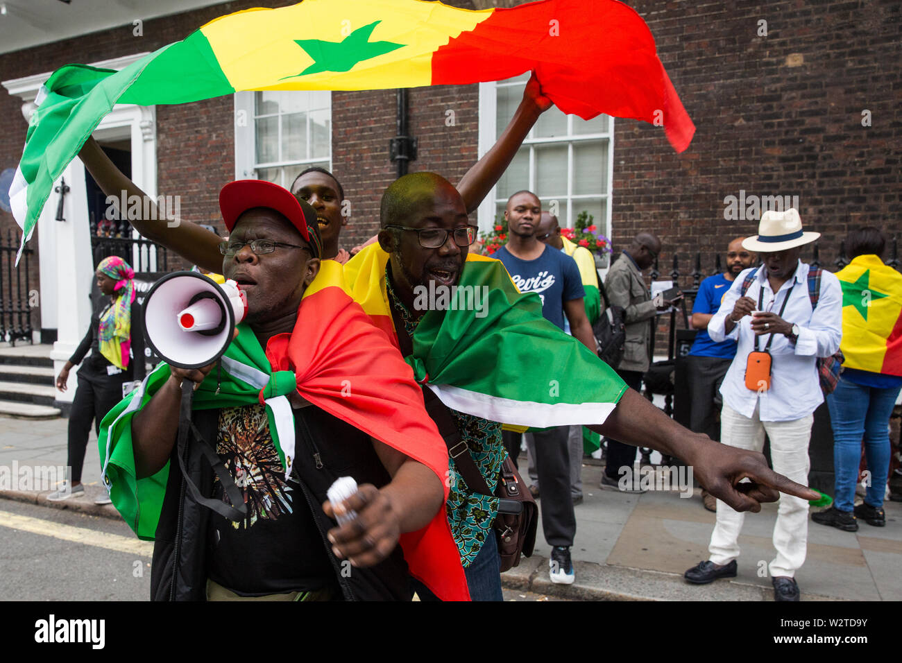 Londra, Regno Unito. 10 Luglio, 2019. I membri della comunità senegalese nel Regno Unito che Senegalese di sostegno alla società civile circolazione Aar Li Ñu Bokk protesta al di fuori di Chatham House durante una intervista di Evan Davis di BP Group Chief Executive Bob Dudley per discutere il bilanciamento crescenti fabbisogni di energia con considerazioni relative ai cambiamenti climatici. La protesta è seguita una BBC Panorama exposé su un $10bn benzina e gas lo scandalo di corruzione in Senegal per il quale esse dispongono di BP responsabile, nonché la concessione di un olio di sfruttamento attraverso il contratto di Timis Corporation. Credito: Mark Kerrison/Alamy Live News Foto Stock