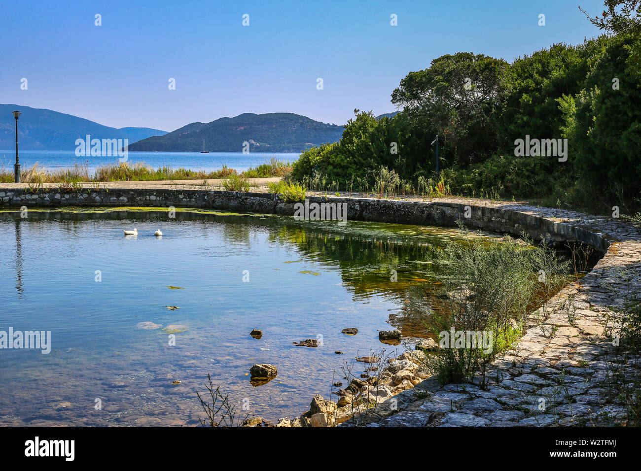La magnifica vista del lago Karavomilos e il mare sullo sfondo vicino al villaggio di Sami presso l'isola di Cefalonia in Grecia. La bellezza del concetto di natura. Foto Stock