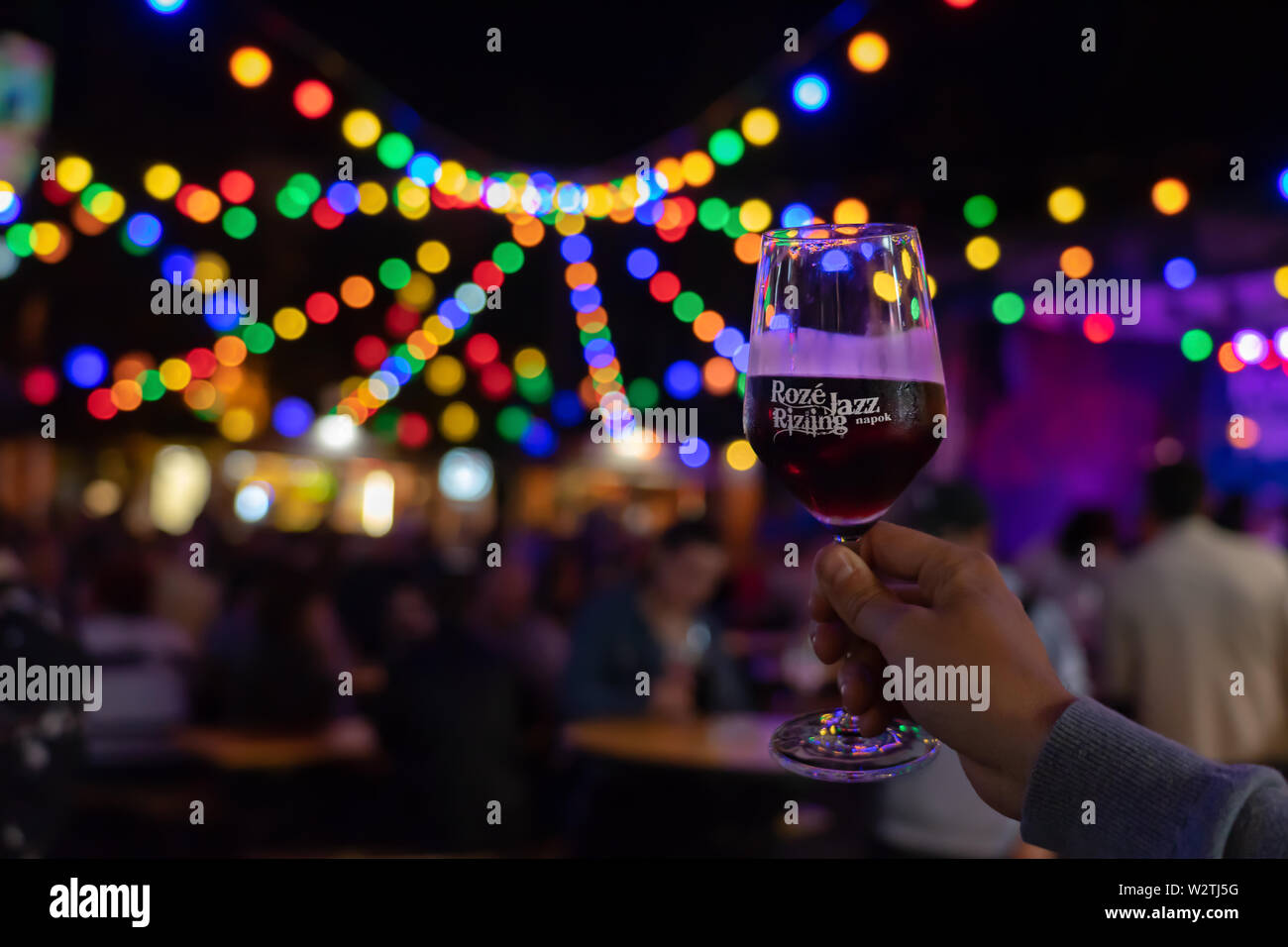 Belgioioso, Italia / 07. 08.2019: Roze Jazz Rizling giorni a Veszprém summer festival evento con luce bokeh di fondo e un bicchiere di vino rosso Foto Stock