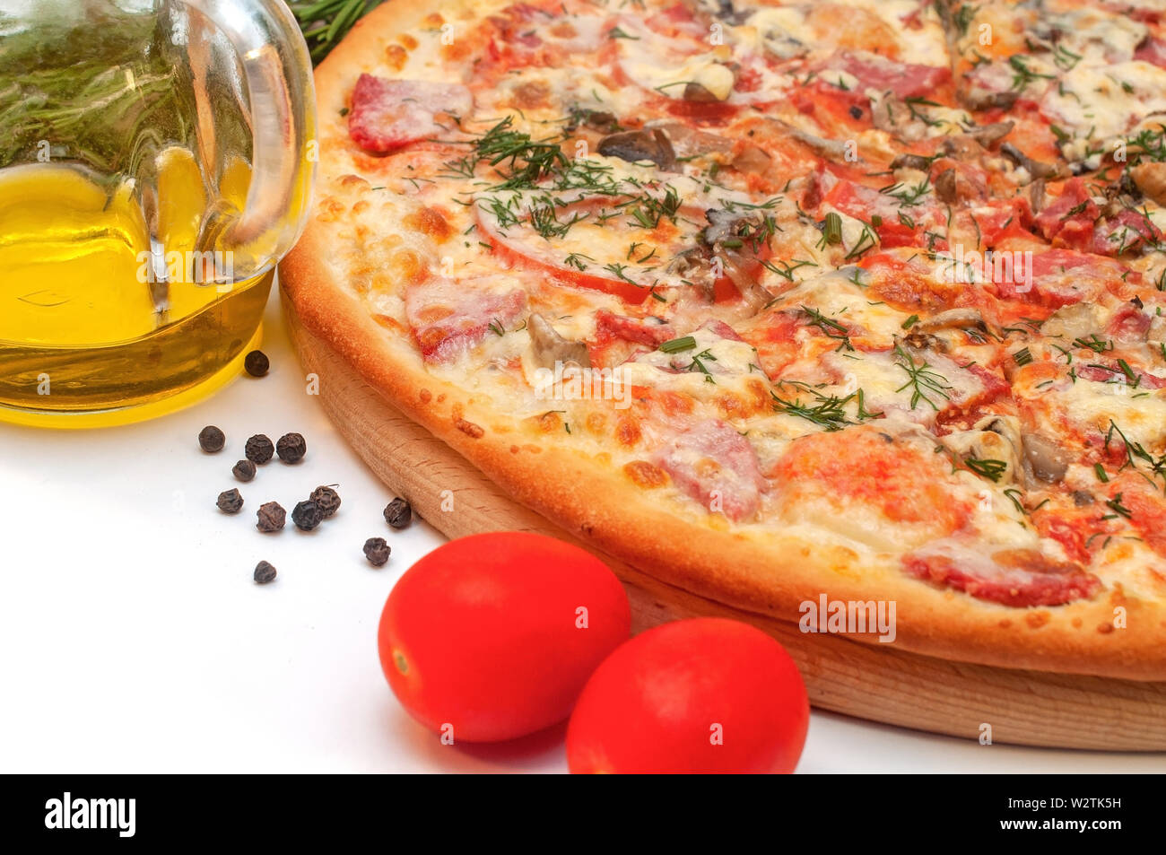 Il pomodoro fresco, fungo, formaggio e salsicce pizza su un bordo rotondo isolato su bianco Foto Stock