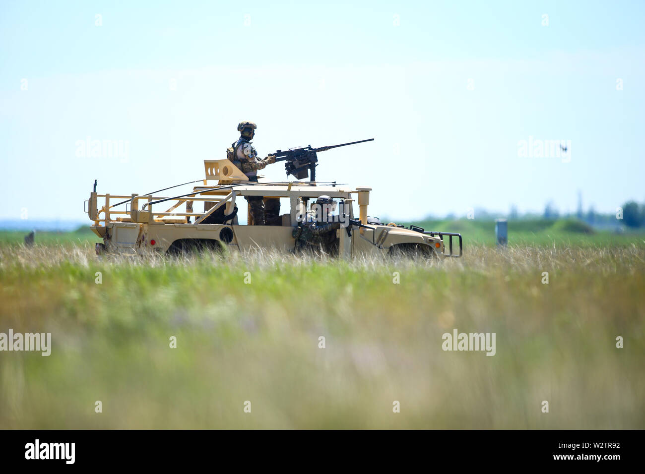 Boboc, Romania - 22 Maggio 2019: soldati rumeni uomo un Humvee veicolo blindato su un campo su una soleggiata giornata estiva durante un drill. Foto Stock