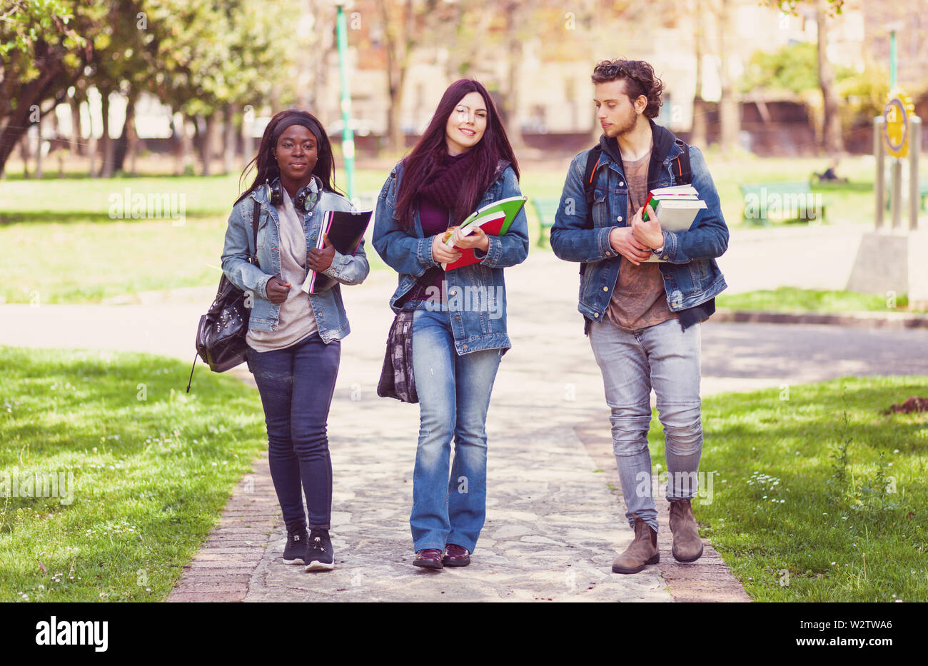 Tre giovani studenti nel parco all'aperto. Multirazziale concetto di gruppo. Foto Stock
