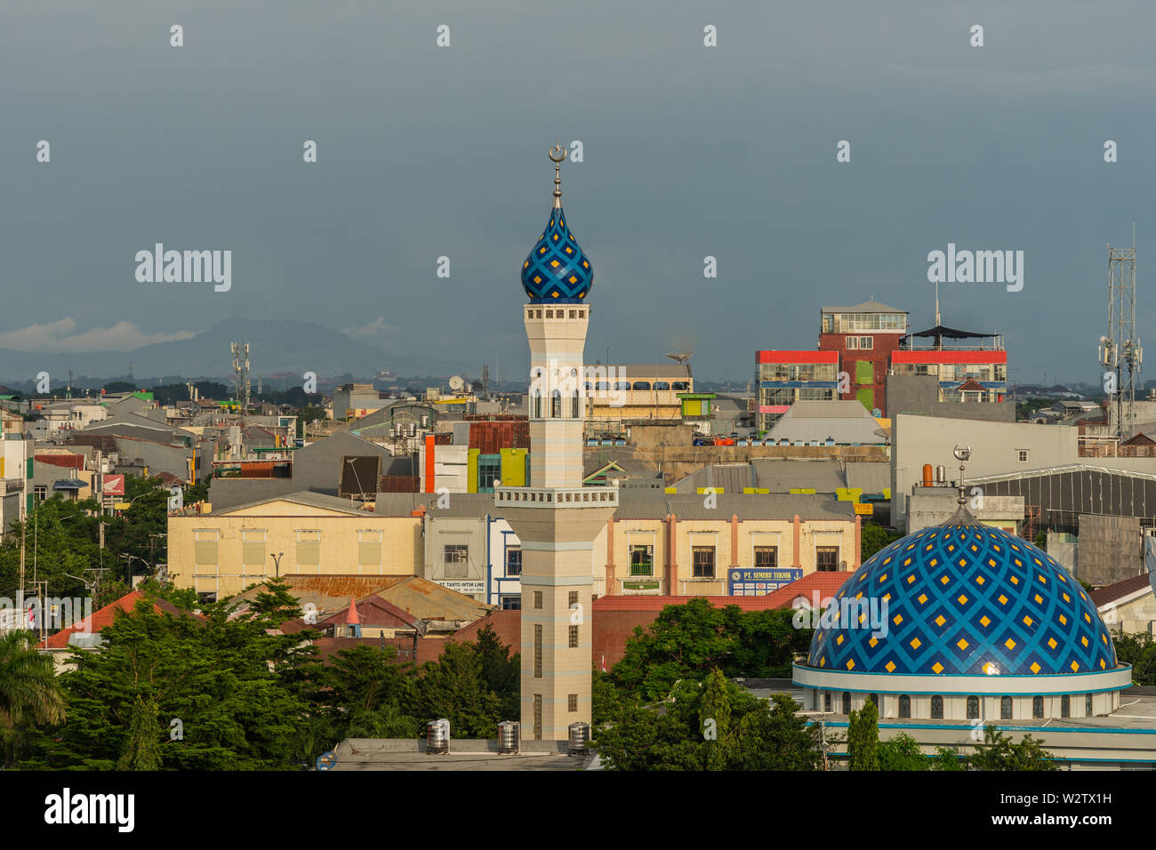 Makassar, Sulawesi, Indonesia - 28 Febbraio 2019: Masjid Babulssalam Pelabuhan moschea con cupola e minareto di fronte a grandi lo skyline della citta'.. Sto di pioggia Foto Stock