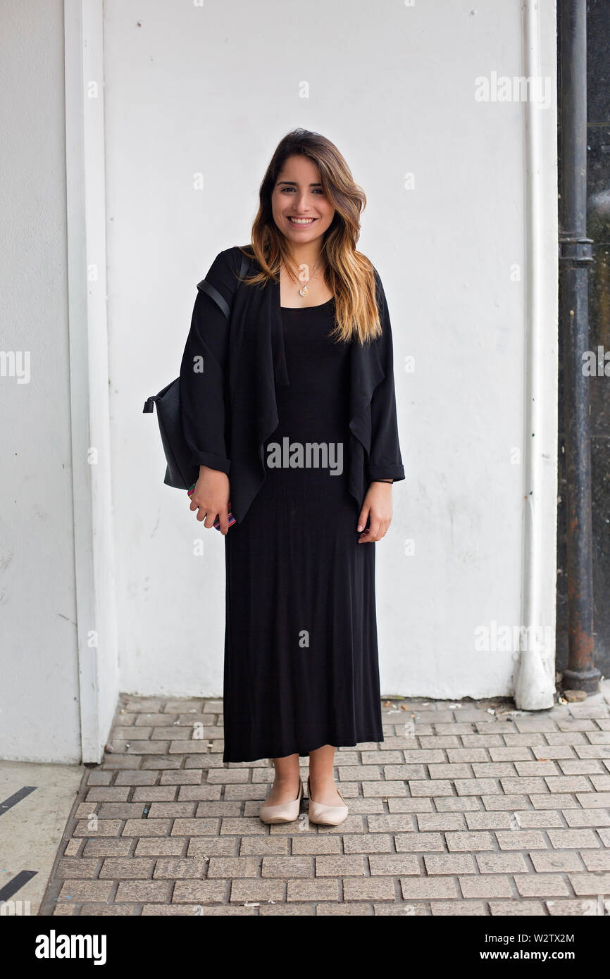 Caucasian woman standing all'angolo della piazza, Bournemouth, Regno Unito, con un informale confortevole minimalista di stile di moda Foto Stock