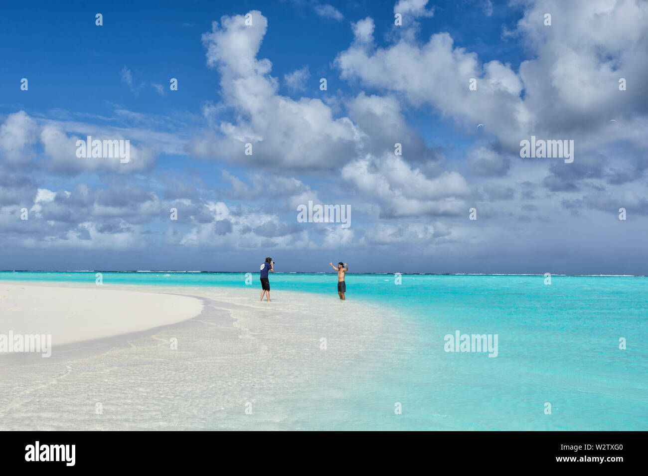 Tourist in posa per una fotografia su una spiaggia di sabbia bianca a laguna turchese di Aitutaki, Isole Cook, Polinesia Foto Stock