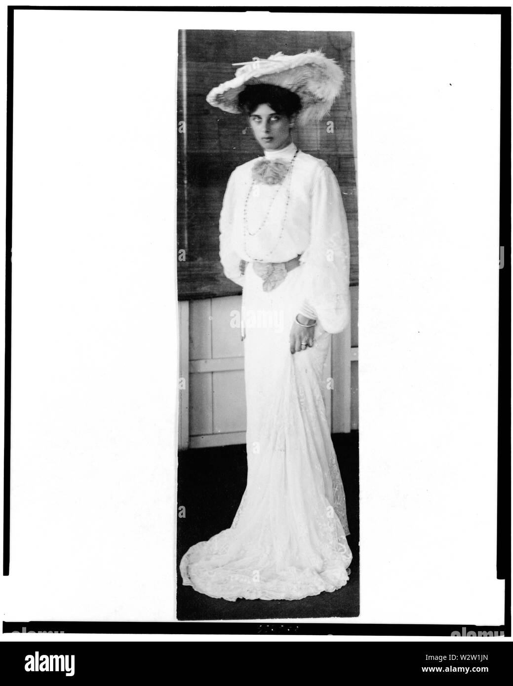 Solita Solano, ritratto a figura intera, in piedi, rivolto leggermente verso sinistra, indossando il lungo abito bianco e hat Foto Stock