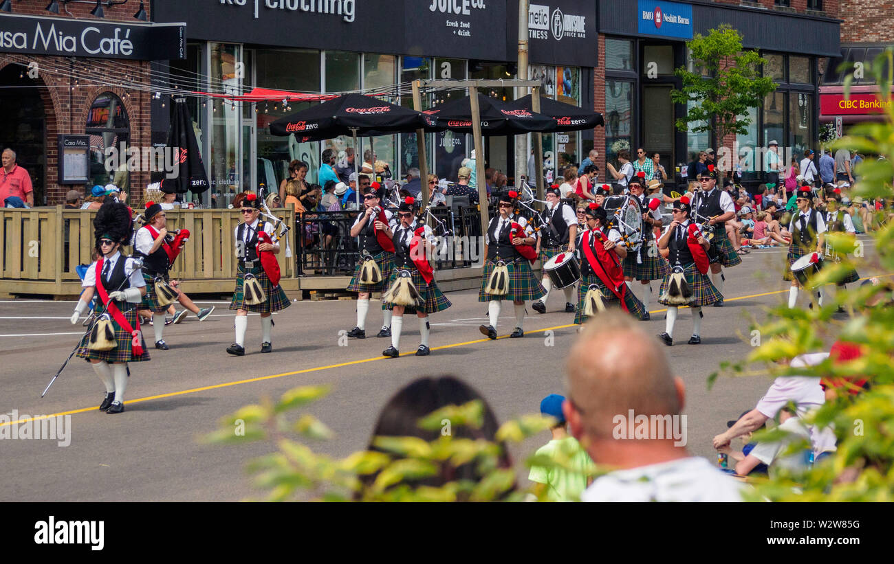 I membri del tubo e del tamburo band marzo giù per la strada nella Gold Cup sfilata per celebrare il PEI della vecchia Home settimana e in estate nel centro della città di Charlottetown, Prince Edward Island, Canada Foto Stock