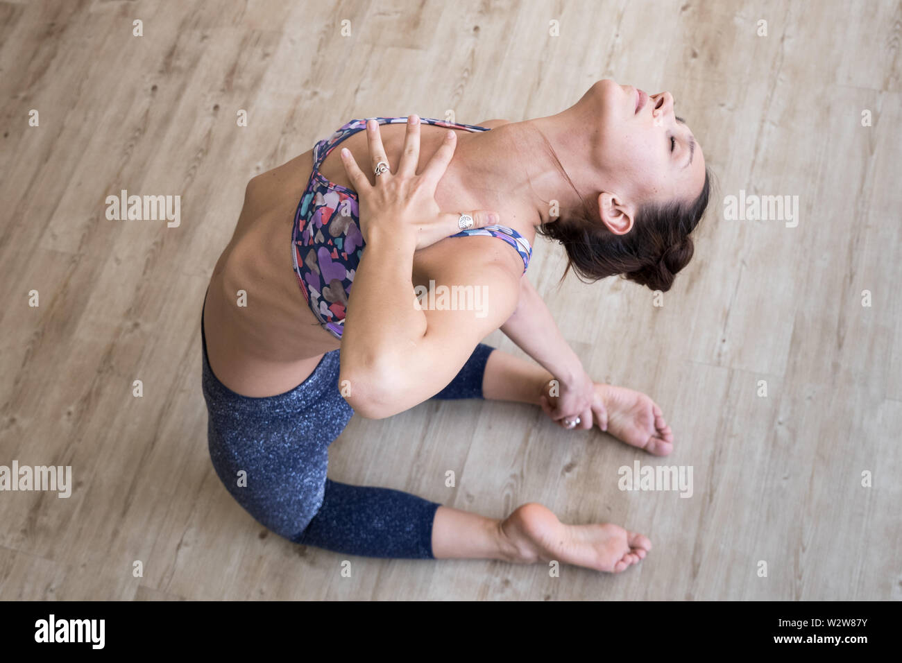 Montare sportivo ragazza attiva in sportswear facendo yoga esercizio fitness in studio di yoga. Attiva uno stile di vita urbano. Foto Stock