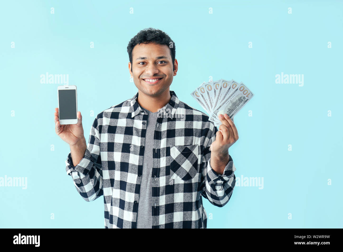 Uomo bello con telefono cellulare e denaro sul colore di sfondo Foto stock  - Alamy