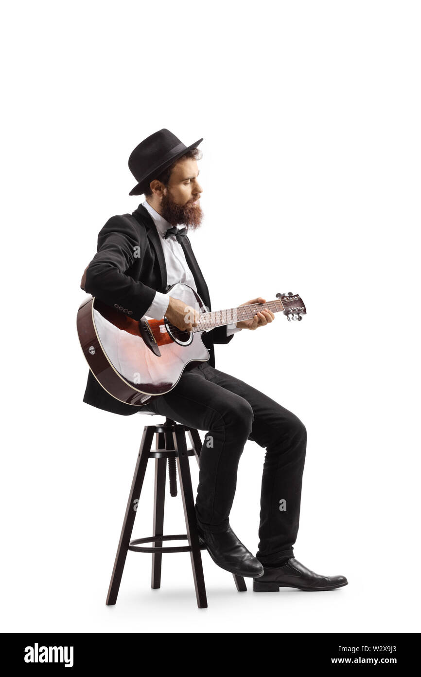 A piena lunghezza shot di un uomo seduto su una sedia e suonando una chitarra acustica isolati su sfondo bianco Foto Stock