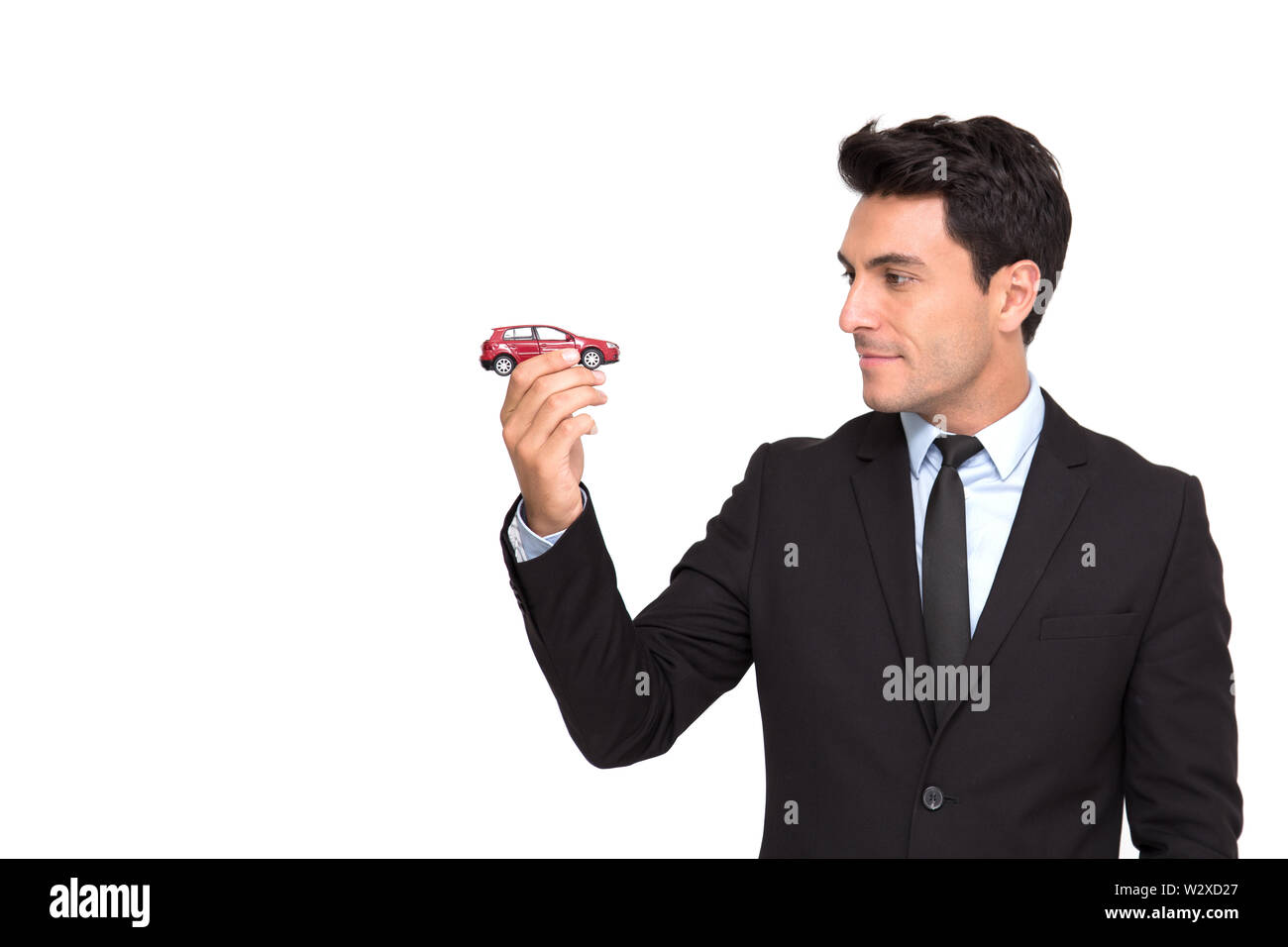 Ritratto di un affascinante imprenditore vestito in tuta azienda giocattolo auto mentre in piedi isolato su sfondo bianco, assicurazione auto e servizi auto conce Foto Stock