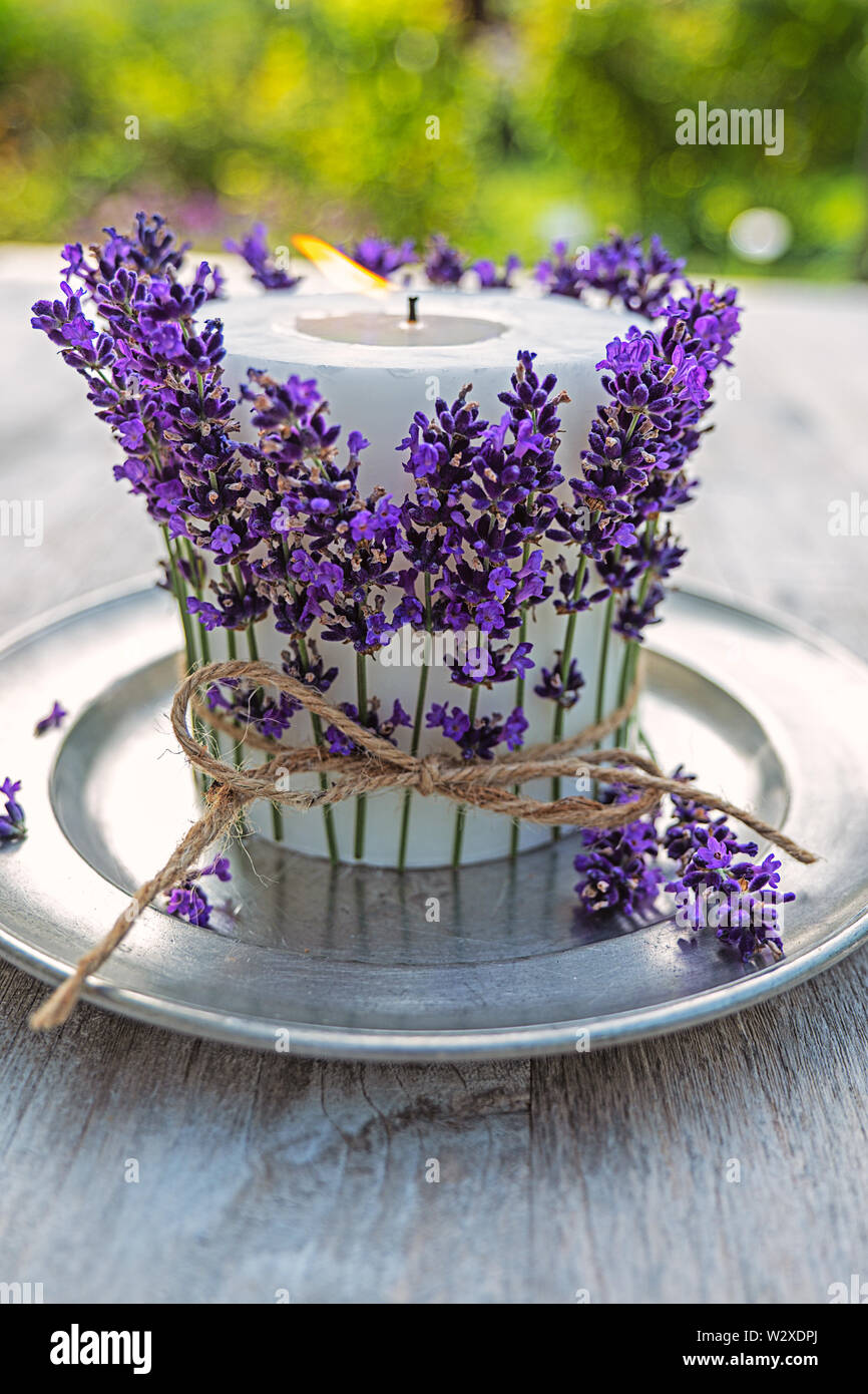 Candela bianco decorato con lavanda sulla piastra in peltro Foto Stock