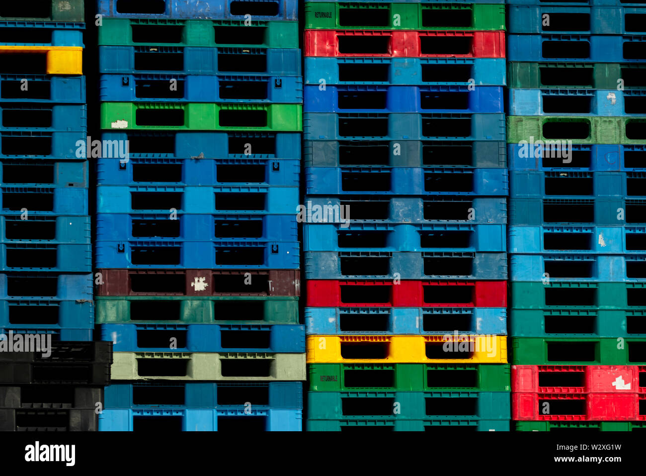 Plastica pallet di spedizione in vendita e in affitto business. L'industria plastica pallet impilati in fabbrica a magazzino. Carico e Spedizione il concetto di business. Foto Stock