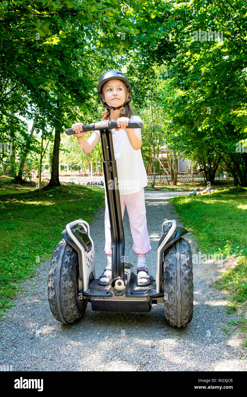 Ragazza giovane ride su segway nel parco d'estate. Foto Stock