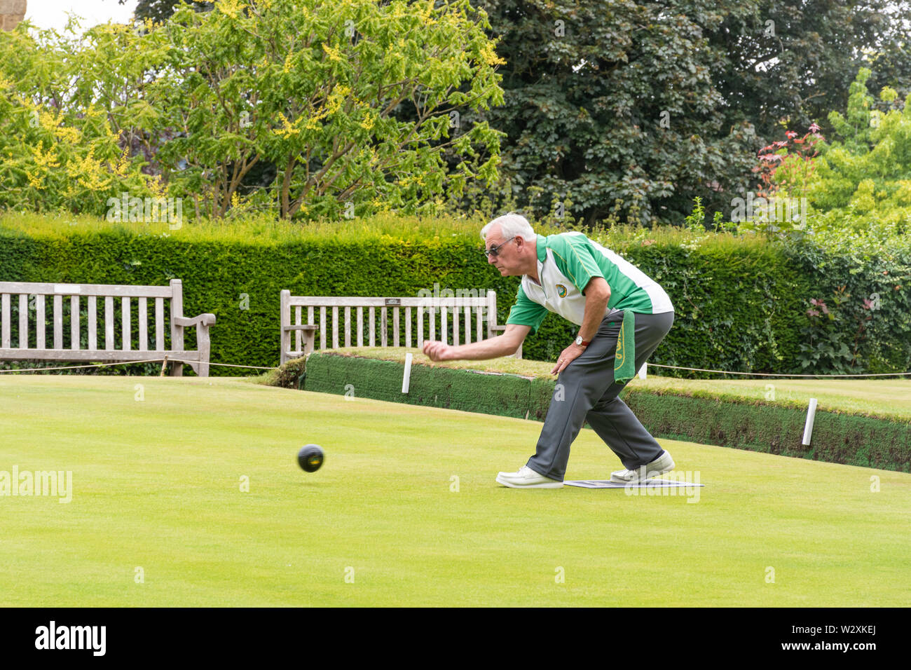 Uomo anziano che gioca a bocce sul campo da bowling. Bowling per anziani, Regno Unito Foto Stock