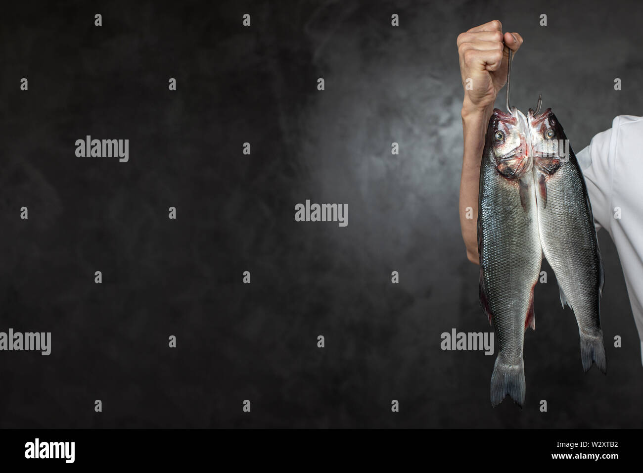 Lo chef senza volto holding crudo fresco pesci Foto Stock