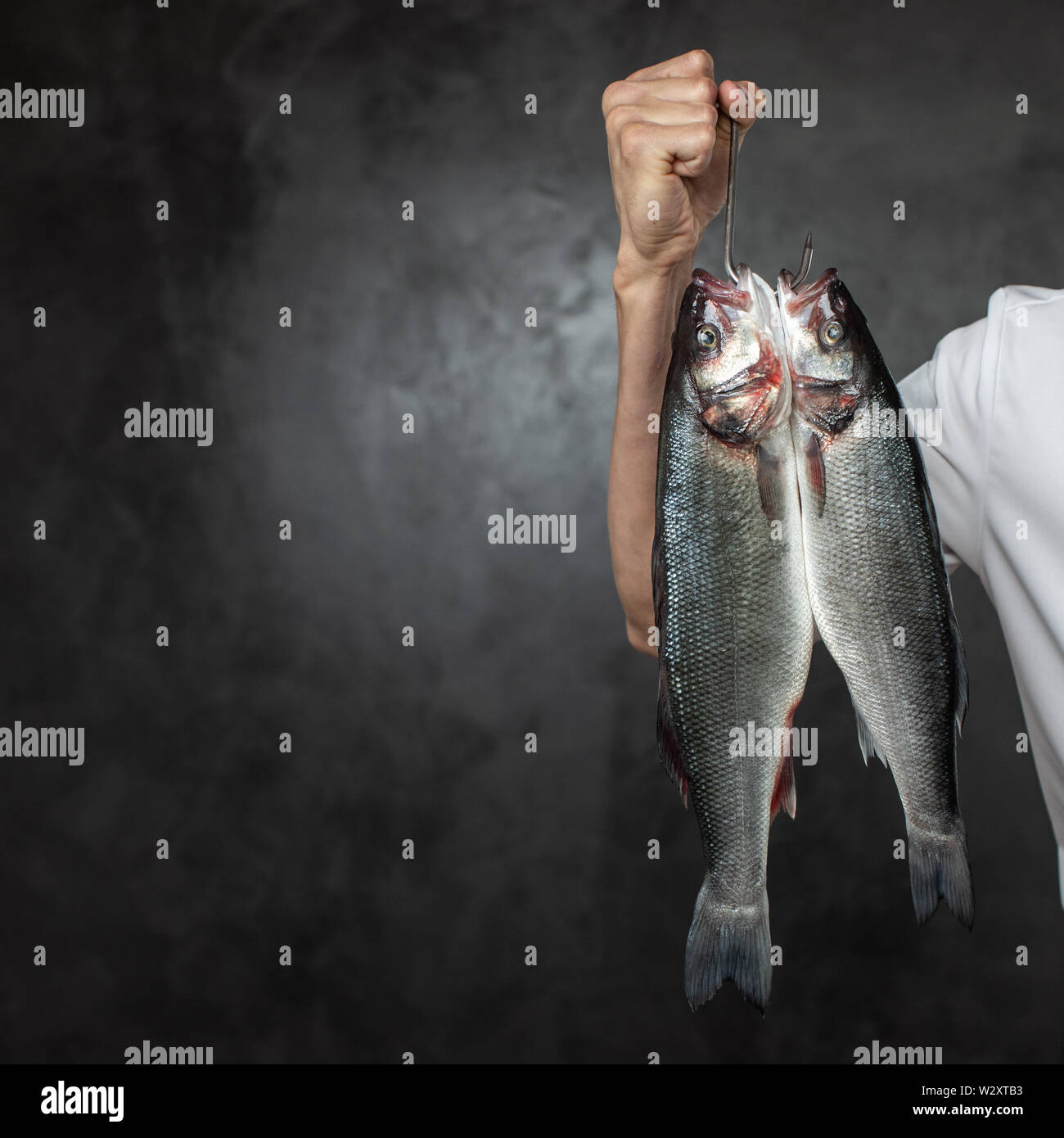 Lo chef senza volto holding crudo fresco pesci Foto Stock